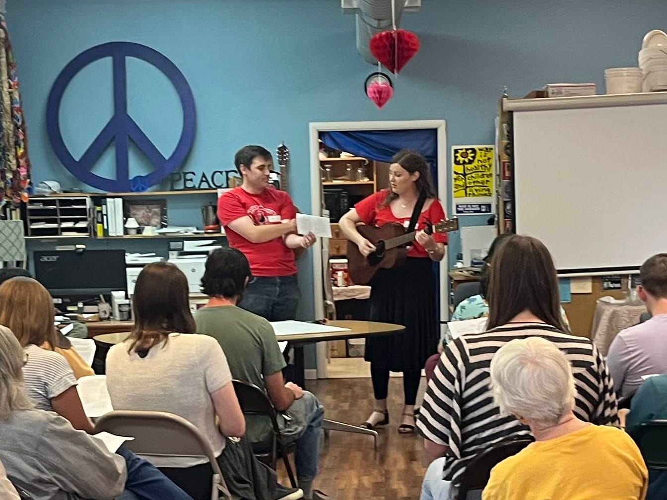 Photo from SoCo DSA's DSA 101 featuring two members leading a song, one playing an acoustic guitar.